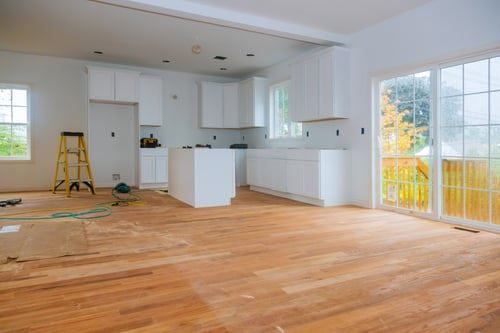 New hardwood flooring being installed in an open kitchen